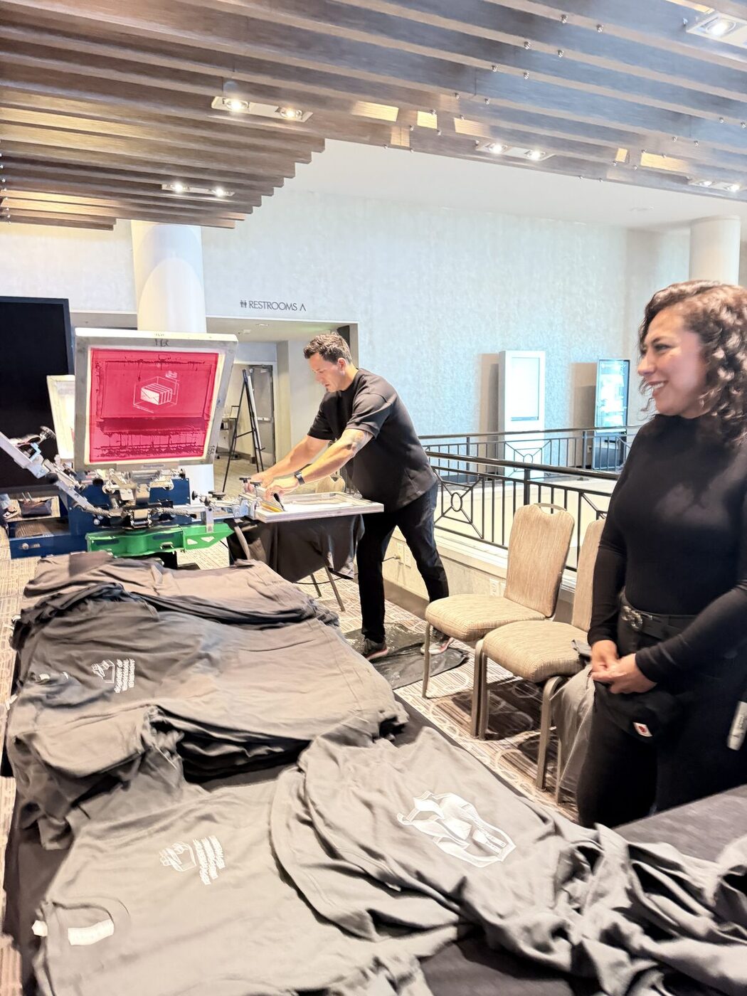 Merch Troop staffer working the heat press at an event